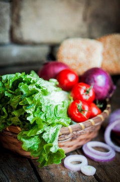 Fresh vegetables in the basket on wooden background