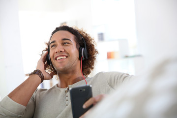 Cheerful attractive man listening to music © goodluz