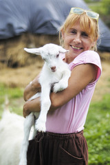 little white goat in the hands of women