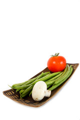 Plate with green beans, tomato and mushroom.
