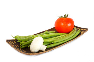 Green beans, tomatoes and mushrooms on a plate.