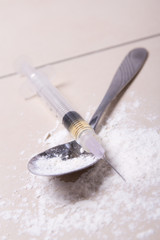 close up of syringe with drug substance, heroin powder and spoon