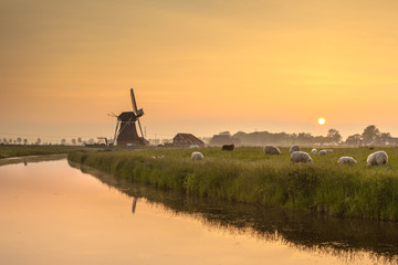 Naklejka premium Dutch Polder Landscape during Orange Sunset