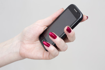 Woman holds the mobile phone in hand