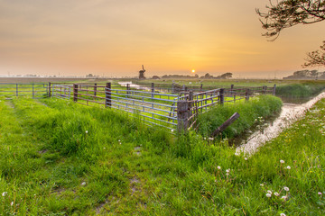 Fototapeta premium Polder Landscape with Orange Sunset In Groningen, Netherlands