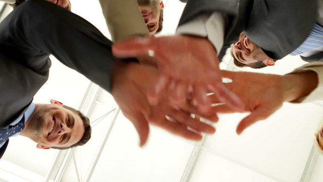 Business people putting hands together low angle view