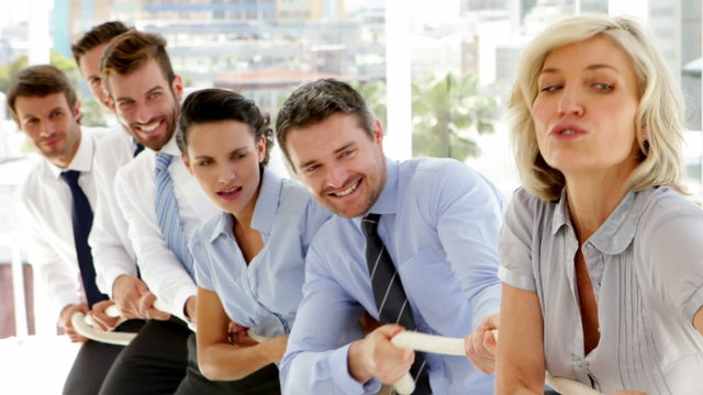 Business people pulling a rope with effort