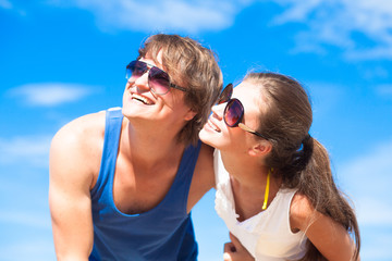 Closeup of happy young couple in sunglasses smiling