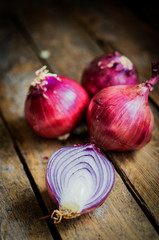 Red onions on rustic wooden background
