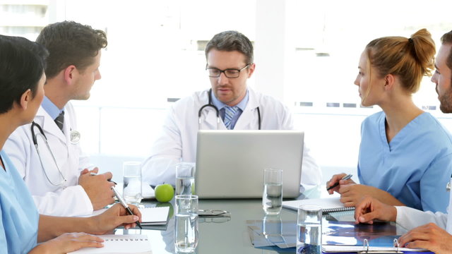 Doctor talking with his staff during a meeting