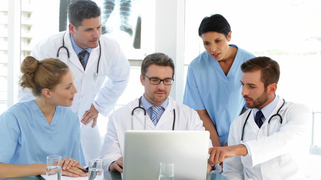 Doctor chatting with his staff during a meeting