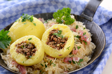 Kartoffelknödel mit Hackfleischfüllung auf Speckkraut