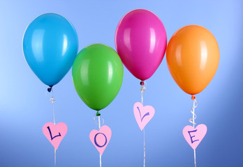 Colorful balloons keeps word "love" on blue background