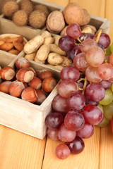 Obraz premium Grape with nuts on wooden table