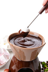 Chocolate fondue with marshmallow candies, isolated on white