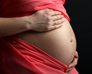 Pregnant woman with coral material isolated on black
