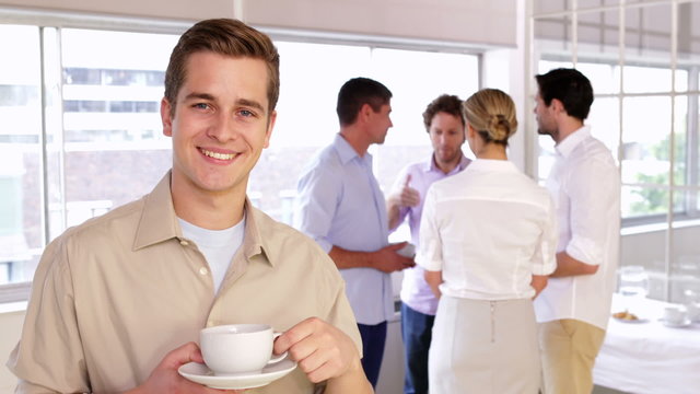 Attractive young businessman posing holding a mug