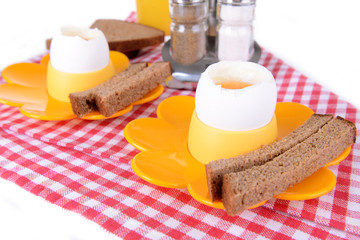 Boiled eggs in egg cups on table close-up