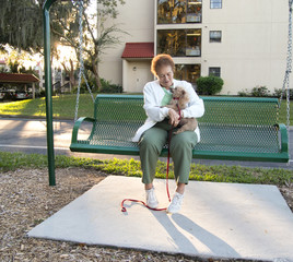 Elderly Lady Sitting on a Swing with Her Dog