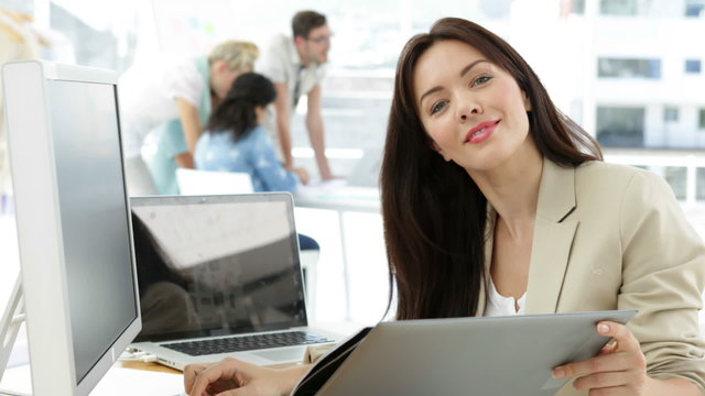 Woman working at her desk looking at folder