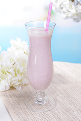 Milk shake on table on light blue background