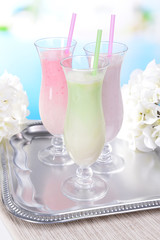 Milk shakes on table on light blue background