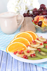 Sweet fresh fruits on plate on table close-up
