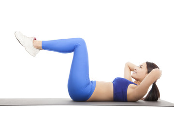 Fit blonde doing pilates core exercise in studio