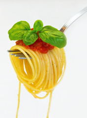 Spaghetti na widelcu z bazylią i sosem na białym tle. - obrazy, fototapety, plakaty