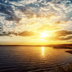 sunset over dark river
