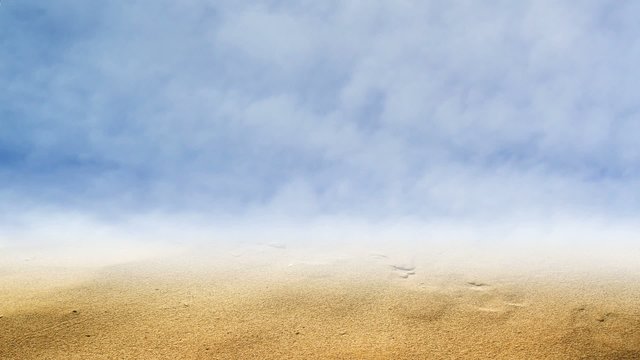 Desert land with brown sand, blue sky with clouds
