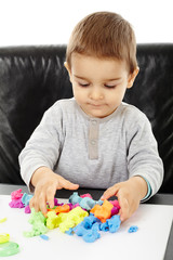 Little boy playing with plasticine