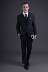 Retro fifties fashion young businessman wearing dark suit and ti