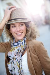 Cheerful blond woman in town with hat on