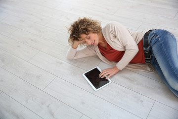 Woman laying on the floor with digital tablet