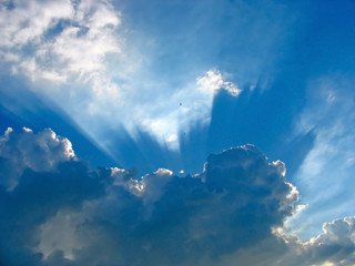 Blue sky with sun rays through the clouds