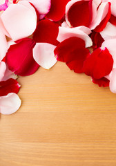 Rose petal over the wooden background