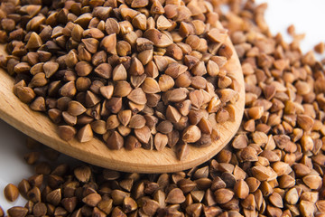 Buckwheat seeds on wooden spoon in closeup