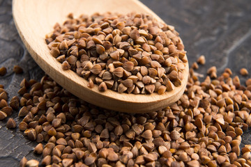 Buckwheat seeds on wooden spoon in closeup