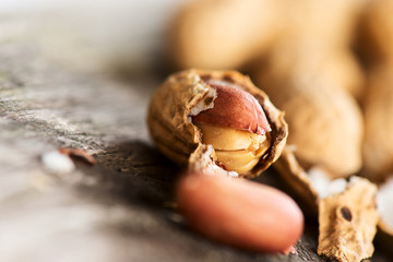 Peanuts in shell on wooden table crashed close up