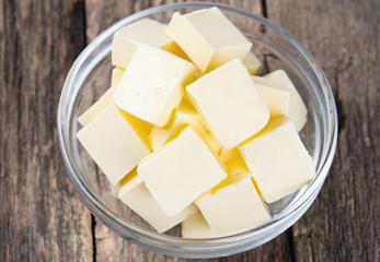 fresh butter in a glass bowl on wooden surface