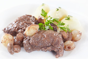 Chicken in red wine with onions, mushrooms and bacon