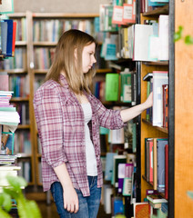 Pensive student in the library surrounded by books