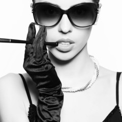 Fashionable model in vintage sunglasses smoking