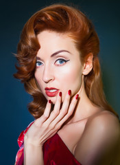 Beautiful caucasion lady with red hair touching her face.