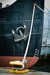 Nose of the moored ship with an anchor on a board