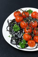 black spaghetti with baked tomatoes, parmesan cheese