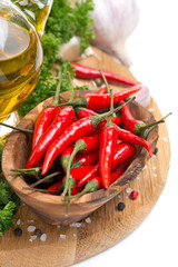 fresh chili pepper garlic, spices and oil on a wooden board