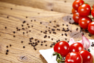 Red tomatoes with pepper and garlic on old wooden table