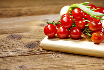 Red tomatoes with pepper and garlic on old wooden table